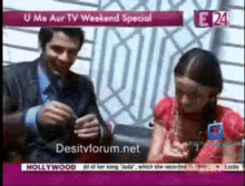 a man and a girl are sitting in front of a screen that says desitvforum.net