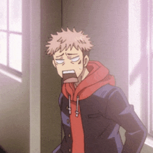 a man in a red hoodie is standing in a hallway with his mouth open
