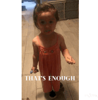 a little girl standing on a tiled floor with the words that 's enough written below her