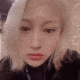 a close up of a woman 's face with short blonde hair and red lips .