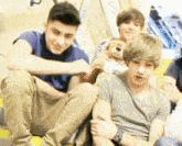 a group of young men are sitting on a staircase one of them holding a teddy bear
