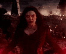 a woman in a black dress with red eyes is holding red lights