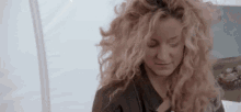 a woman with curly hair is wearing a stethoscope around her neck .