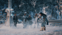 a group of people are standing in the snow and one of them is holding a child