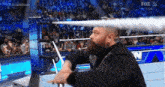 a man with a beard is standing in a wrestling ring with a fox live logo behind him