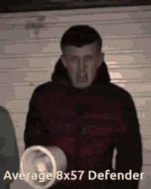 a man in a red jacket is holding a bucket with the words average 8x57 defender on it
