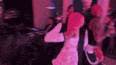 a blurry photo of a person dancing in a room with pink lights