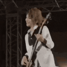 a woman is playing a guitar on a stage in a dark room .
