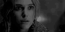 a close up of a woman 's face in a black and white photo with a surprised look on her face .