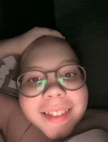 a young girl wearing glasses has a green square on her lens