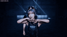 two women are dancing in front of a blue light and the words honeycam.org are visible