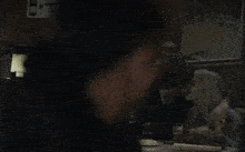 a blurry picture of a man smoking a cigarette in a dark room .