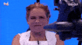 a woman stands in front of a camera that says tvi on it