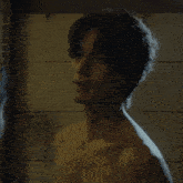 a shirtless man is looking at another shirtless man in a bathroom mirror .