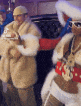 a woman in a fur coat is dancing next to a man in a fur coat ..