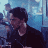 a man is sitting at a table with a straw in his mouth and drinking a drink .