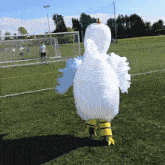 a person in an inflatable chicken costume on a field