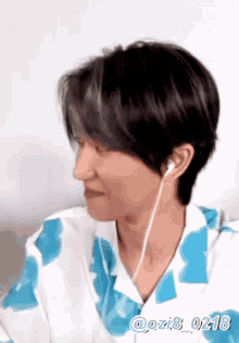 a man wearing headphones and a blue shirt is smiling .