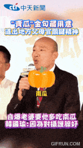 a man in a suit is holding a microphone with a pumpkin in front of him in chinese
