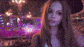 a woman is taking a selfie in front of a crowd at a concert