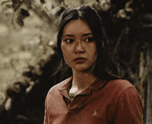 a woman is wearing a red polo shirt with a horse on it
