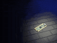 a small electronic device is laying on a black tiled floor