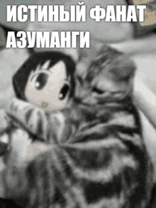 a black and white photo of a cat holding a doll with russian writing