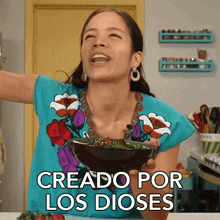 a woman holding a bowl of food with the words creado por los dioses below her