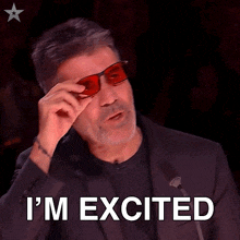 a man is wearing red glasses and says i 'm excited