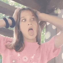 a young girl wearing a pink shirt with a picture of a donut on it