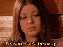 a woman says i 'm sure she 'll be okay while laying on a bed