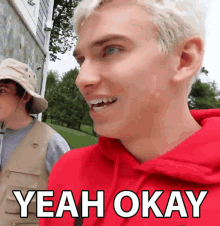a man in a red hoodie says yeah okay in white letters