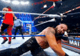 a man is laying on the ground in a wrestling ring with the word man on the wall behind him