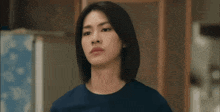 a woman in a blue shirt is sitting in front of a motorcycle mirror