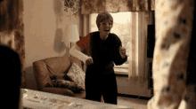 an elderly woman with a broken arm is standing in a living room
