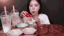 a woman is eating a strawberry and whipped cream dessert
