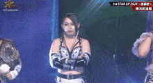 a female wrestler is standing in front of a screen that says stardom