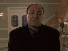 a man in a suit and tie is making a funny face in front of a staircase .
