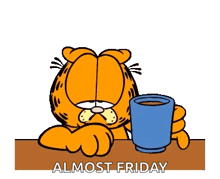 garfield is sitting at a table holding a blue cup of coffee