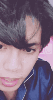 a close up of a young man 's face with a pink lip