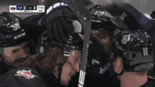 a hockey player wearing a bauer helmet talks to another hockey player