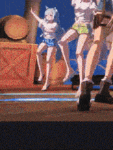 a group of anime girls are dancing together on a stage .