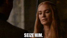 a man with a mustache is standing in front of a wall and saying `` seize him '' .