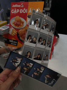 a person is holding a photo booth with a jollibee advertisement in the background