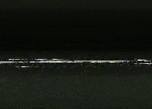 a white lightning bolt is coming out of the ground in a dark room .