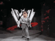 a man in a suit and tie is dancing in front of a w logo