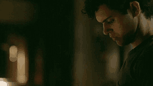 a man is sitting in a dark room reading a book .