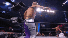 two men are wrestling in a ring with a aew logo on the bottom right corner