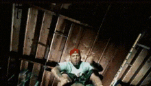 a man in a red hat is sitting on a wooden floor