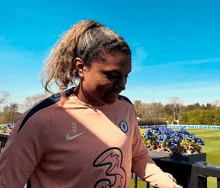 a woman wearing a pink nike jersey with the number 9 on the front